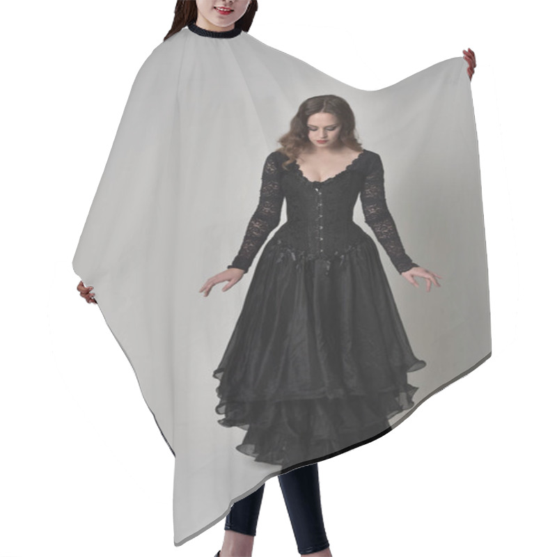 Personality  Full Length Portrait Of Brunette Girl Wearing Long Black Lace Gown Wit Corset. Standing Pose, Isolated On Grey Studio Background. Hair Cutting Cape