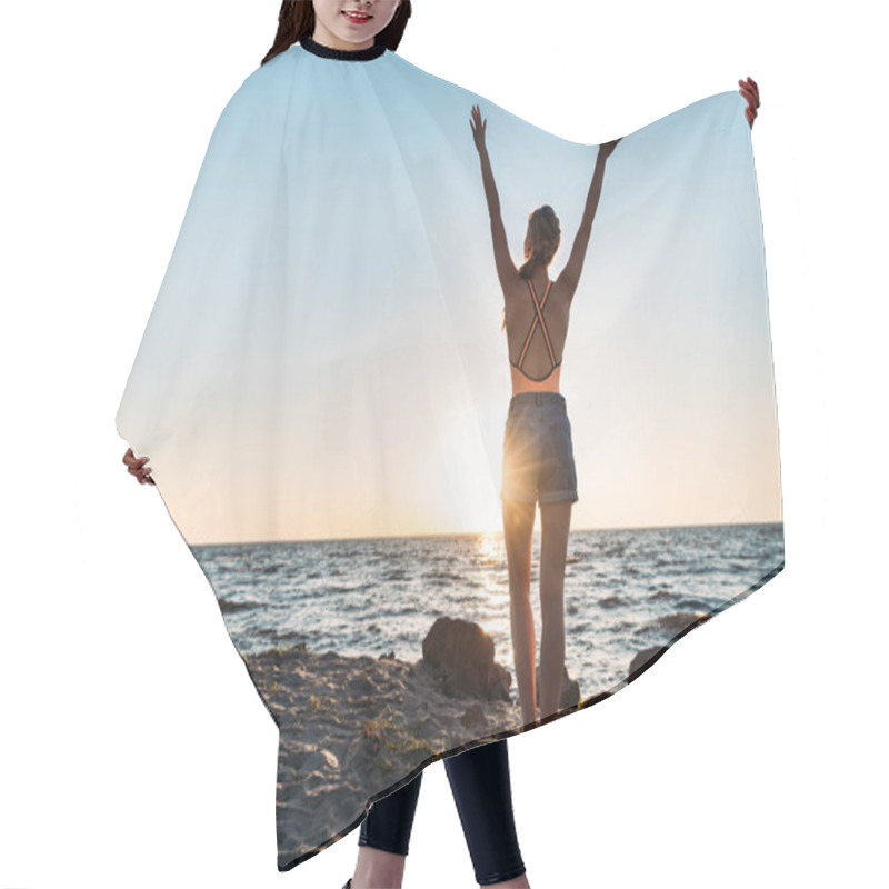 Personality  Back View Of Young Woman Raising Hands While Standing On Sandy Beach At Sunset Hair Cutting Cape