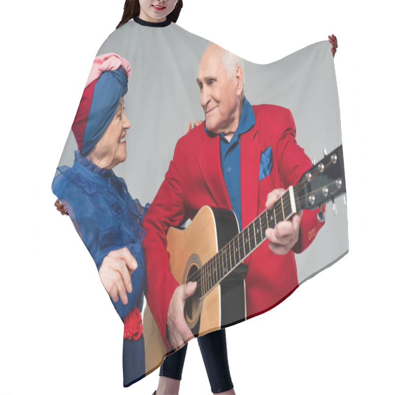 Personality  Smiling Elderly Man In Red Blazer Playing Acoustic Guitar Near Dancing Woman In Blue Dress And Turban Isolated On Grey Hair Cutting Cape