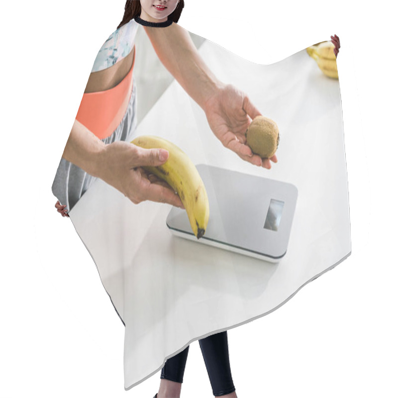 Personality  Cropped View Of Woman Holding Banana And Kiwi Near Food Scales Hair Cutting Cape