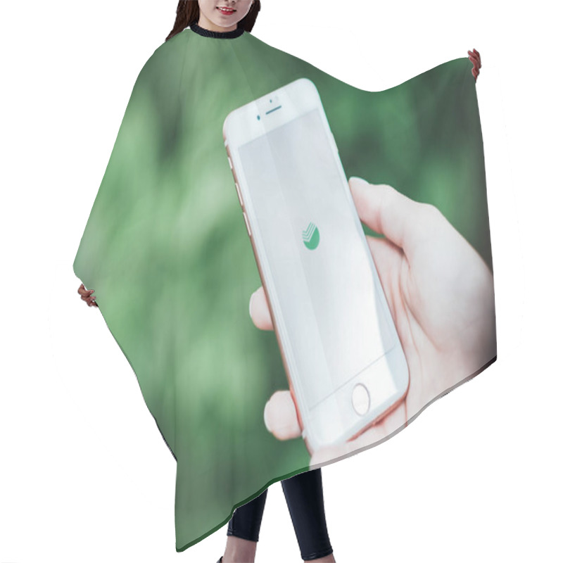 Personality   Hands Holding IPhone With Screen Of Sberbank Online App.  Hair Cutting Cape