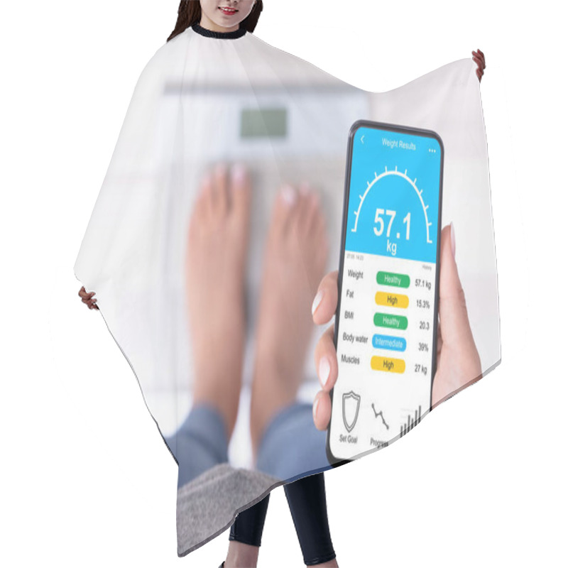 Personality  High Angle View Of A Woman Standing On Weighing Scale Holding Cellphone Hair Cutting Cape