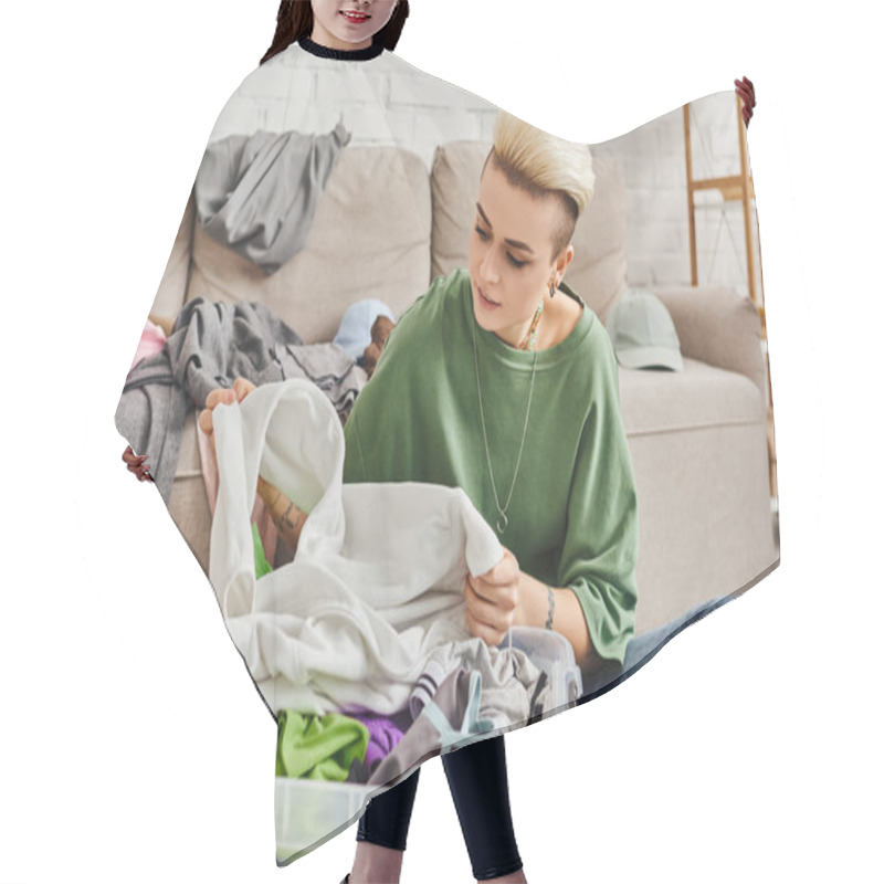 Personality  Young Woman With Tattoo And Trendy Hairstyle Sorting Second-hand Clothes In Plastic Container Near Couch In Modern Living Room, Sustainable Living And Mindful Consumerism Concept Hair Cutting Cape