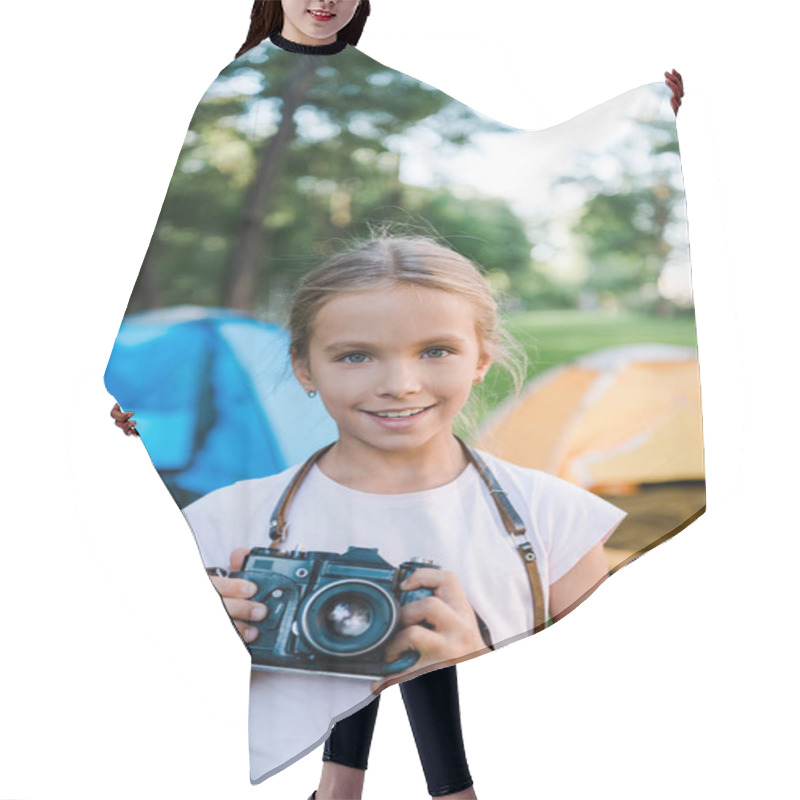 Personality  Happy Kid Holding Digital Camera And Smiling Near Camps  Hair Cutting Cape