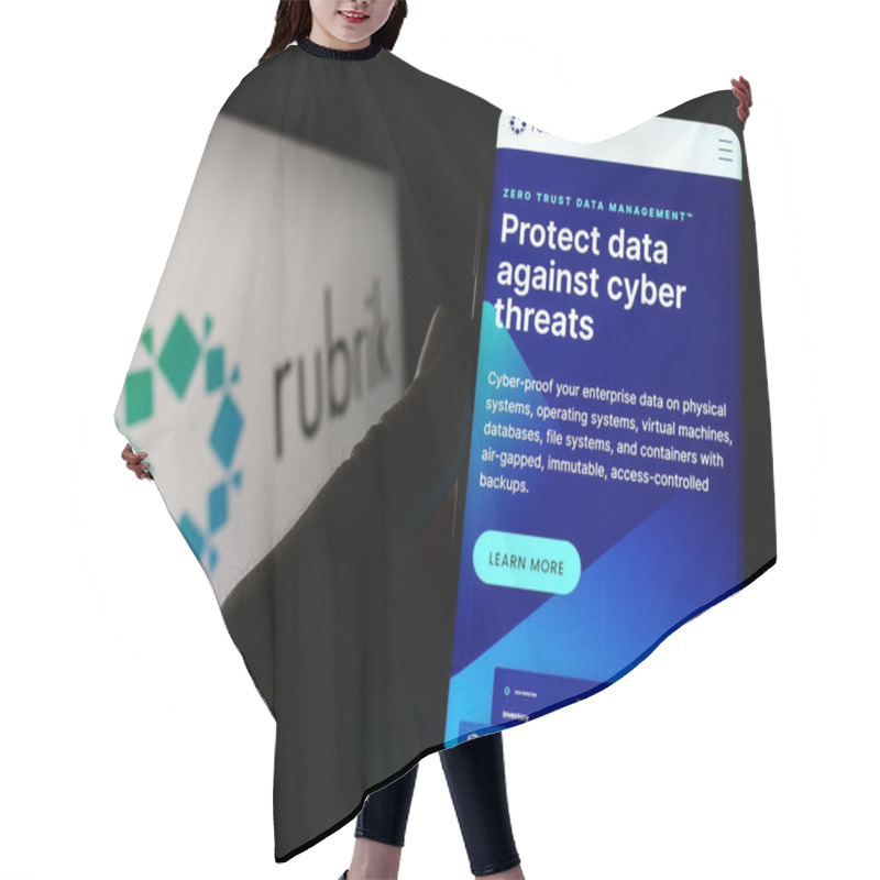 Personality  Stuttgart, Germany - 03-30-2023: Person Holding Cellphone With Webpage Of US Data Security Company Rubrik Inc. On Screen In Front Of Logo. Focus On Center Of Phone Display. Hair Cutting Cape