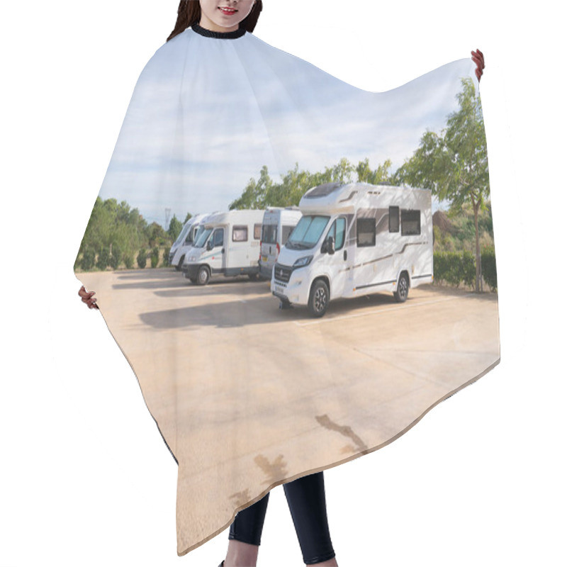 Personality  Motorhomes And Campervans Parked On The Area D`autocaravanes Aire In La Selva Del Camp, Tarragona Province, Spain Using The Water And Waste Services And Parking Hair Cutting Cape