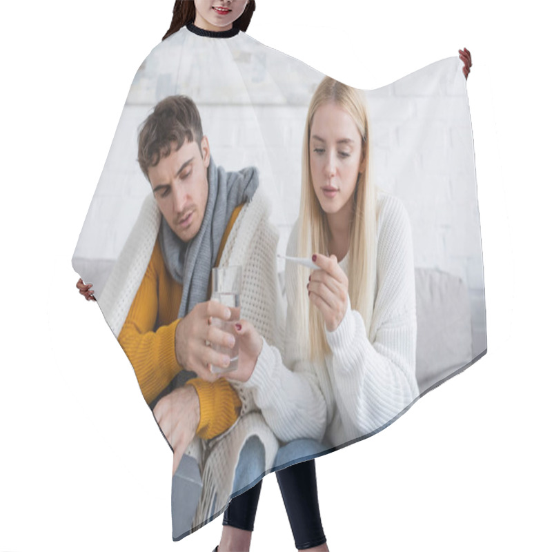 Personality  Young Woman Looking At Digital Thermometer And Giving Glass Of Water To Sick Boyfriend With Tissue Box  Hair Cutting Cape