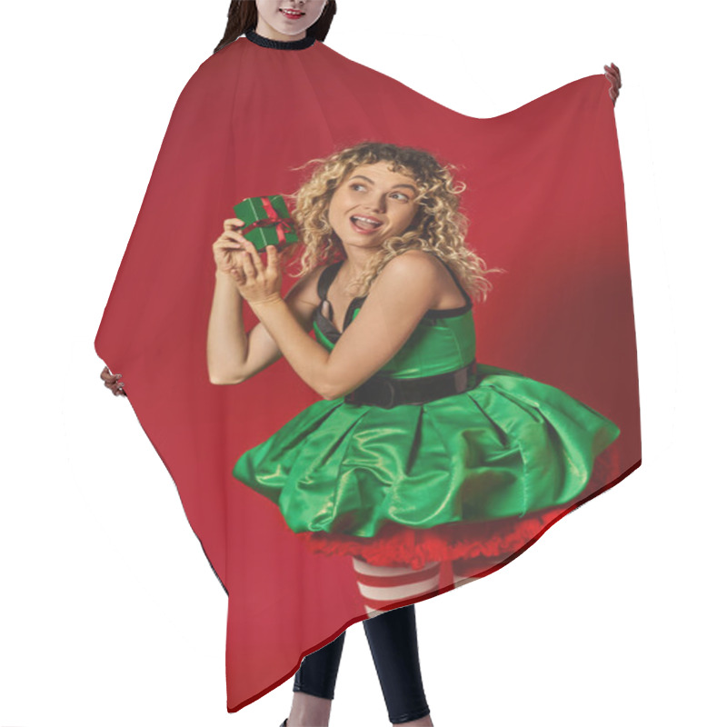 Personality  Astonished New Year Elf In Green Dress And Stockings Holding Present Looking Away On Red Backdrop Hair Cutting Cape