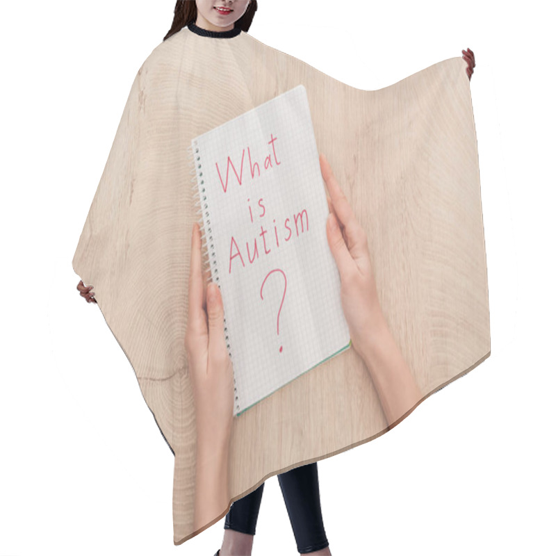 Personality  Cropped View Of Woman Holding Notebook With What Is Autism Question On Wooden Table Hair Cutting Cape