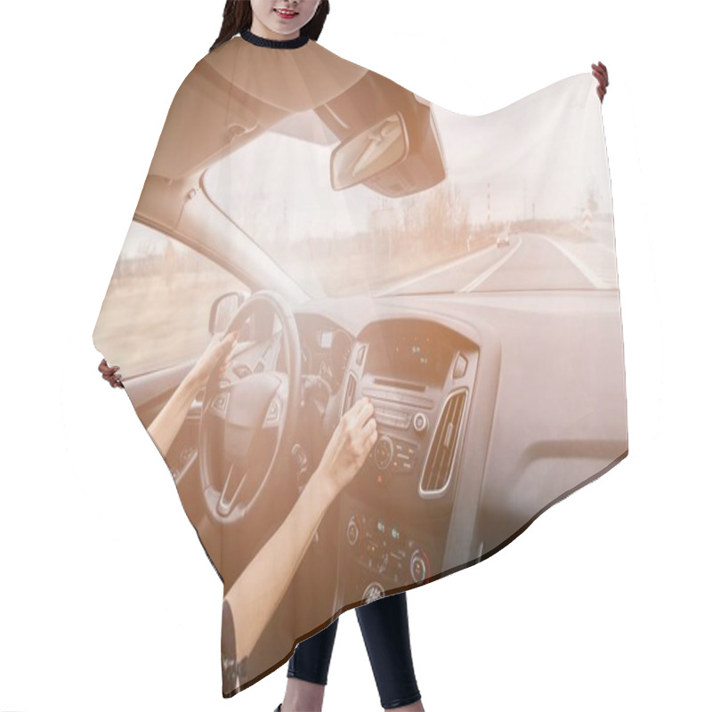 Personality  Young Woman Driving A Car And Adjusting Car Audio. Hair Cutting Cape