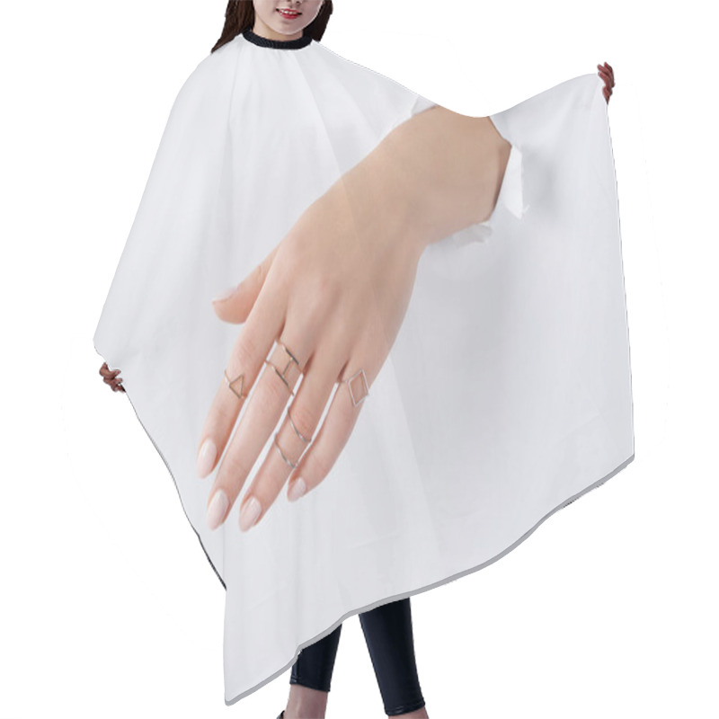 Personality  Cropped Image Of Woman Holding Hand With Beautiful Luxury Silver Rings Through White Paper Hair Cutting Cape