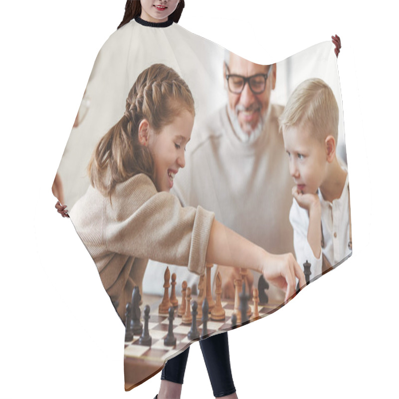 Personality  Children Brother And Sister Playing Chess While Sitting In Living Room With Senior Grandparents Hair Cutting Cape