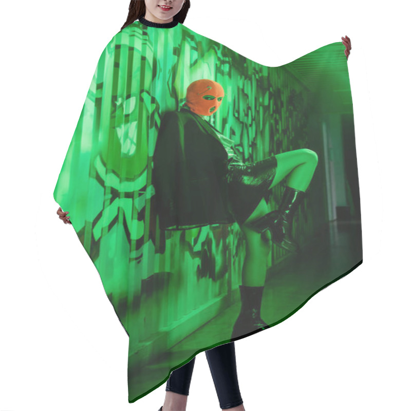 Personality  Full Length Of Sexy Woman In Stylish Leather Boots And Orange Balaclava Standing Near Wall With Graffiti In Green Lighting Hair Cutting Cape