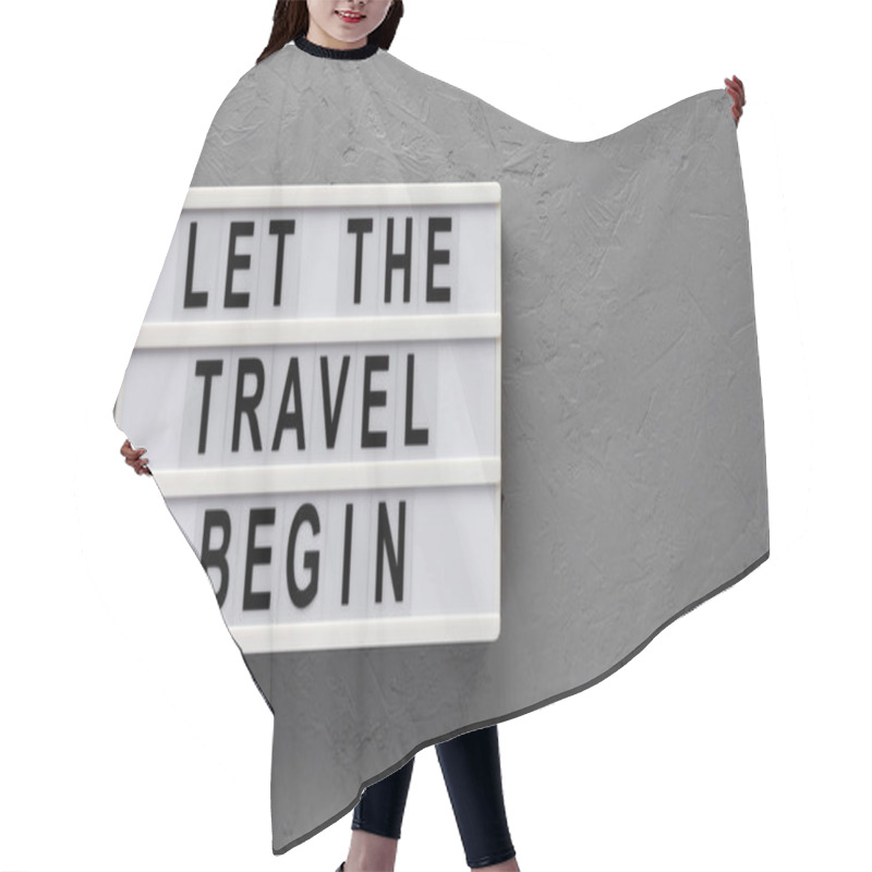 Personality  'Let The Travel Begin' On A Lightbox On A Gray Surface, Top View. Flat Lay, From Above, Overhead. Copy Space. Hair Cutting Cape