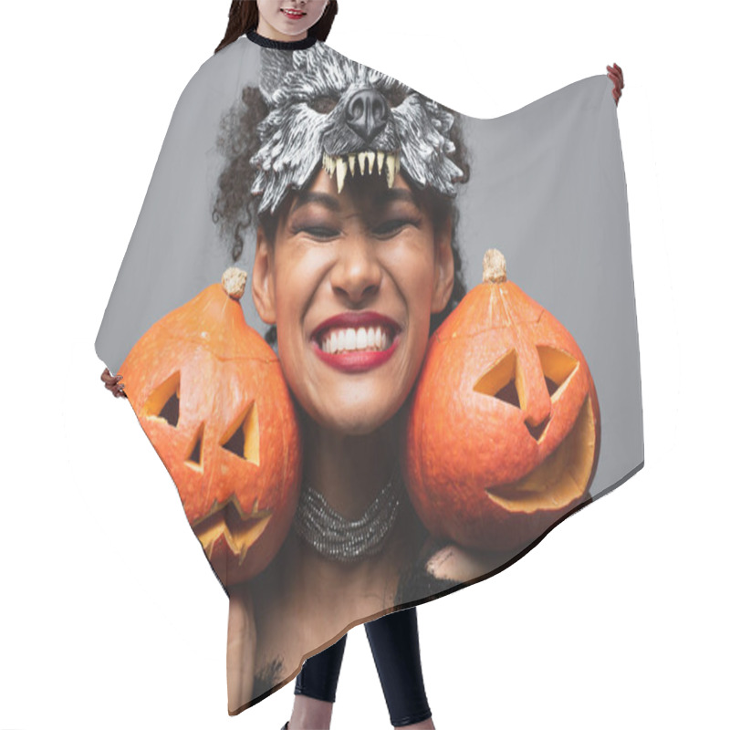 Personality  Overjoyed African American Woman In Wolf Halloween Mask Holding Carved Pumpkins And Smiling With Closed Eyes Isolated On Grey Hair Cutting Cape