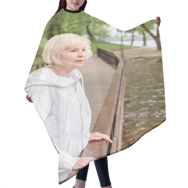 Personality  Lonely Senior Woman Standing Near Railings In Park Hair Cutting Cape