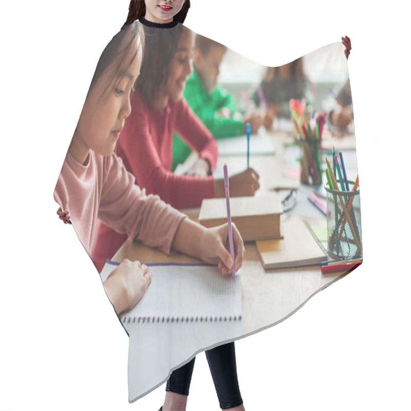 Personality  Korean Schoolgirl Writing Taking Notes Learning During Class Sitting With Multicultural Classmates In Classroom At School. Modern Education Concept. Selective Focus, Cropped Hair Cutting Cape