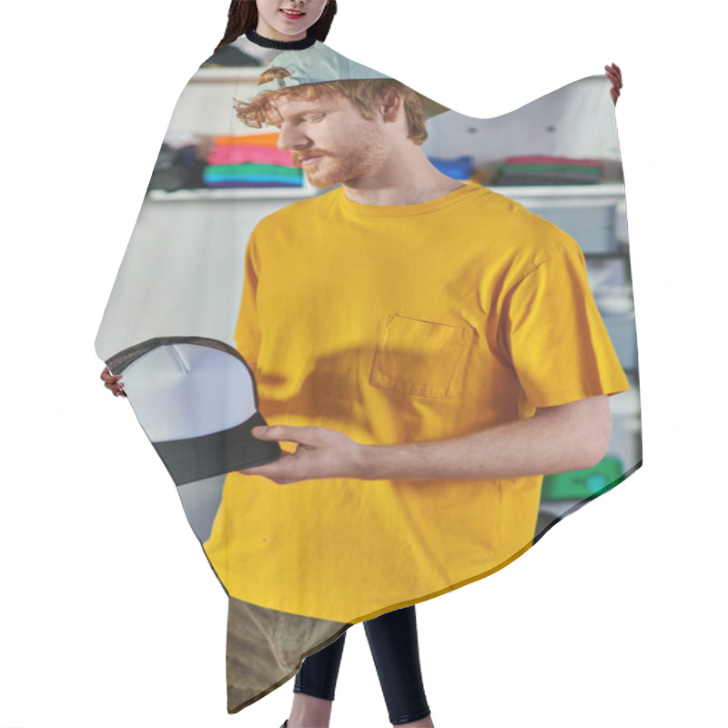 Personality  Young Redhead Craftsman Holding Snapback While Working On Project And Standing In Blurred Print Studio At Background, Small Business Resilience Concept Hair Cutting Cape