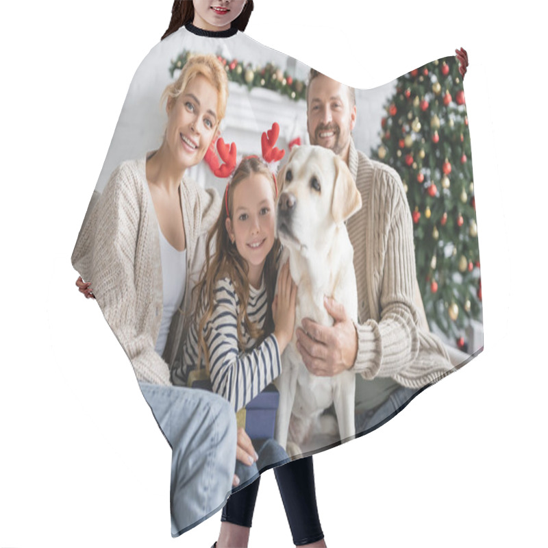 Personality  Smiling Parents Looking At Camera Near Daughter With Christmas Headband Hugging Labrador At Home  Hair Cutting Cape