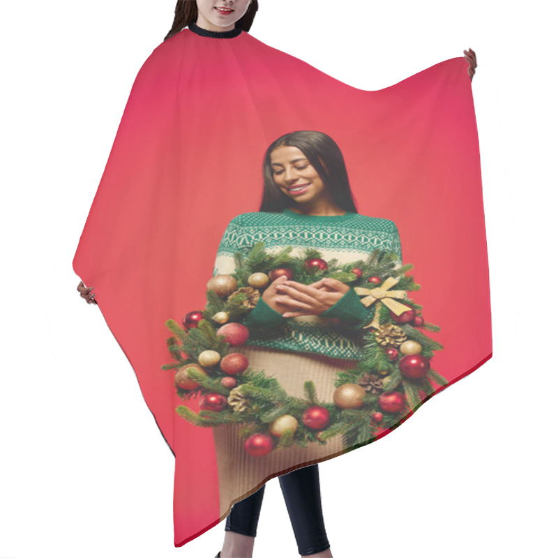 Personality  A Joyful Young Woman Beams While Cradling A Beautifully Decorated Holiday Wreath. Hair Cutting Cape