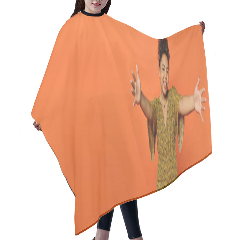 Personality  Man Extends Arms In Front Of Vibrant Orange Background. Hair Cutting Cape