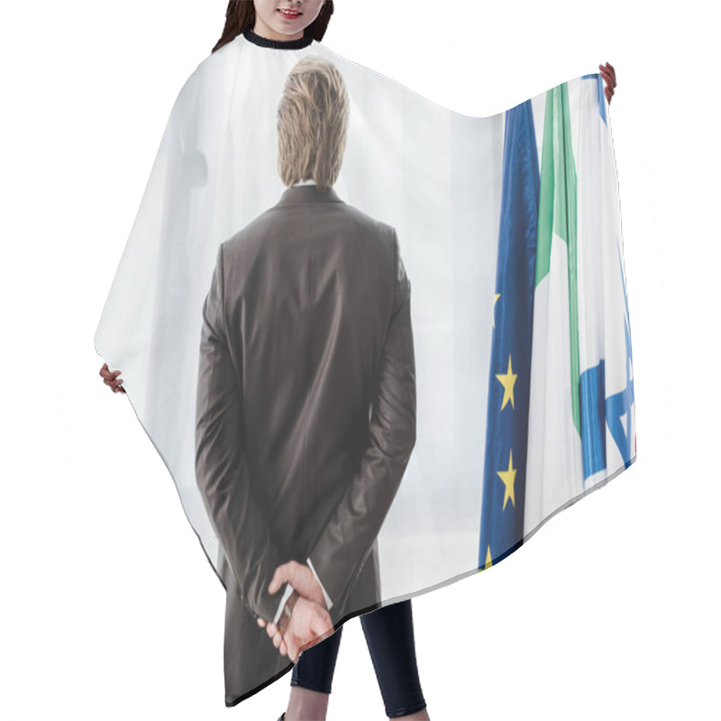 Personality  Back View Of Diplomat Standing With Clenched Hands Near Flags  Hair Cutting Cape