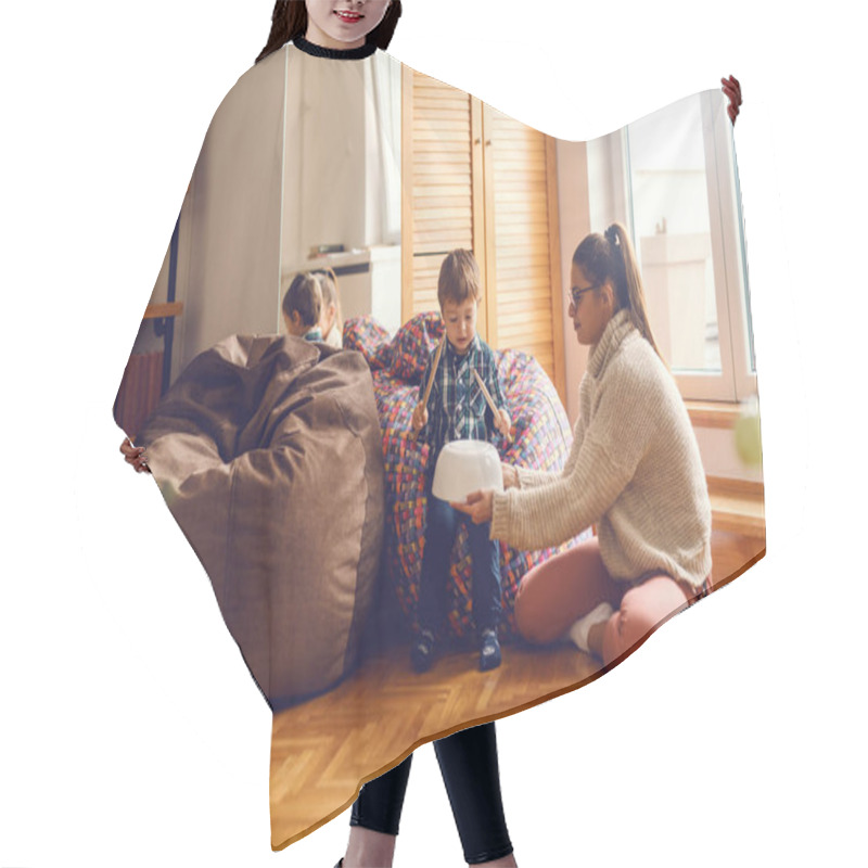 Personality  Little Boy Sitting In Bean Bag And Pretending To Play Drums While His Mother Holding Bowl Upside Down (drums). Home Interior. Hair Cutting Cape