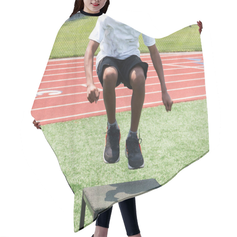 Personality  Front View Of A Young Athlete Jumping Onto A Plyo Box During A High School Summer Sports Camp. Hair Cutting Cape