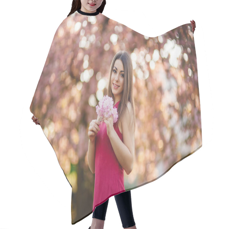 Personality  Young Girl Posing For A Photo. Flowering Pink Trees In The Background. Spring. Sakura. Hair Cutting Cape