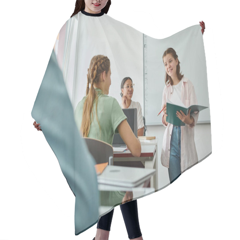 Personality  Positive Teen Schoolgirl Holding Notebook Near Classmate And African American Teacher In Classroom Hair Cutting Cape