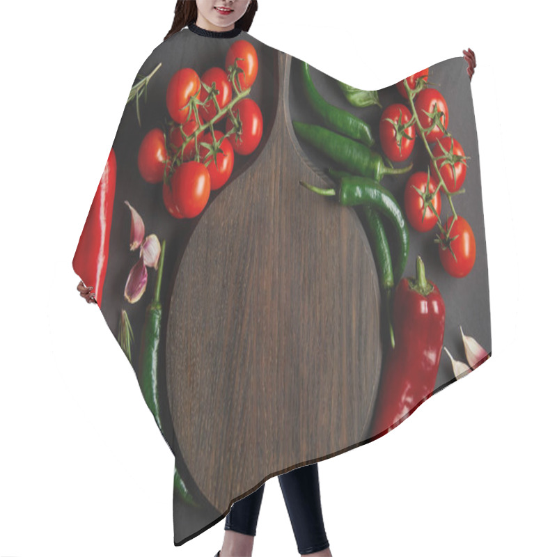 Personality  Top View Of Wooden Chopping Board Near Ripe Cherry Tomatoes, Garlic Cloves, Rosemary, Basil Leaves And Green Chili Peppers On Black Hair Cutting Cape