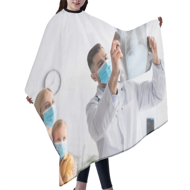 Personality  Pediatrician In Medical Mask Looking At Fluorography Near Blurred Mother Hugging Kid  Hair Cutting Cape