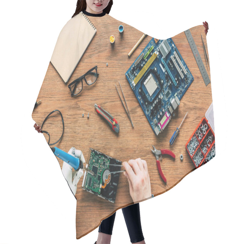 Personality  Cropped Image Of Electronic Engineer With Robotic Hand Soldering Hard Rive At Table  Hair Cutting Cape