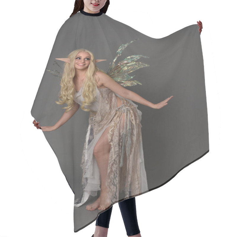 Personality  Full Length Portrait Blonde Girl Wearing Fantasy Fairy Costume, Standing Pose. Grey Studio Background. Hair Cutting Cape