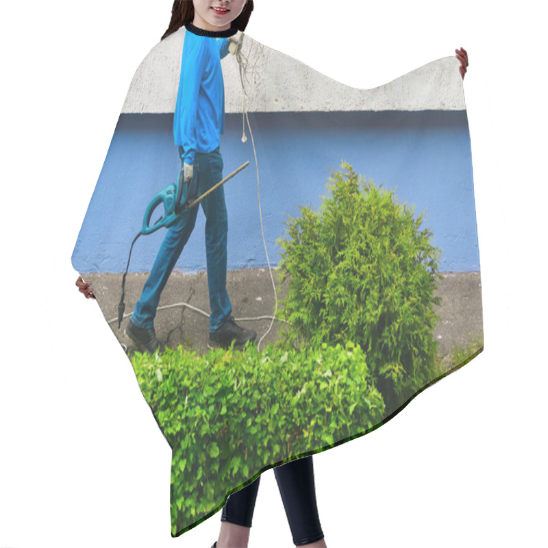 Personality  Worker Holds Bush Clipper And An Electric Wire Extension Cord Hair Cutting Cape