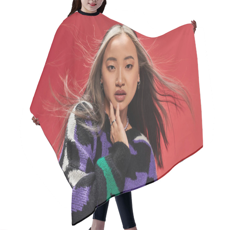 Personality  Charming Young Asian Woman In Vibrant Sweater With Animal Print Touching Cheek On Red Backdrop Hair Cutting Cape