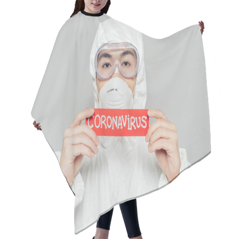 Personality  Asian Epidemiologist In Hazmat Suit And Respirator Mask Holding Warning Card With Coronavirus Inscription Isolated On Grey Hair Cutting Cape