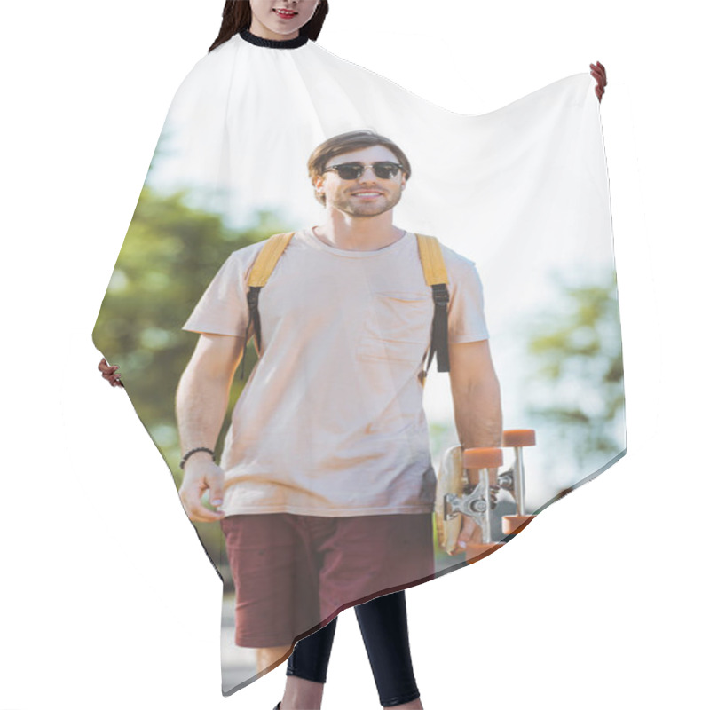 Personality  Portrait Of Young Man In Sunglasses With Backpack And Longboard Walking On Street Hair Cutting Cape