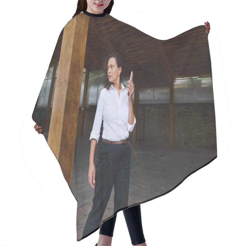 Personality  A Confident Businesswoman Stands In A Spacious Wooden Interior Holding A Smartphone. She Appears Attentive And Thoughtful, Suggesting A Professional Environment And Focus On Modern Technology. Hair Cutting Cape