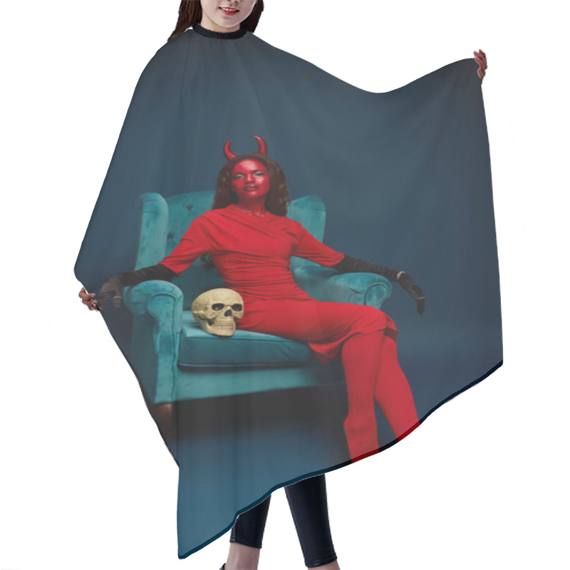 Personality  Glamorous Woman In A Striking Red Costume And Horns Sits Elegantly Beside A Decorative Skull. Hair Cutting Cape