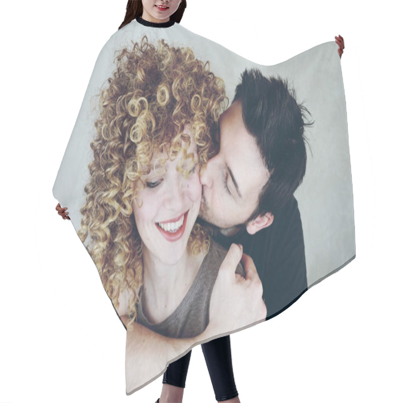 Personality  Portrait Of A Natural Caucasian Couple Of Young Woman With Curly Blonde Hair And Man. He Kisses Her And She Looks Happy And Smiles Hair Cutting Cape