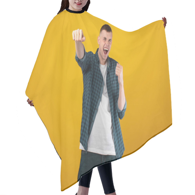 Personality  Emotional Young Man Shouting Celebrating Victory Shaking Fists Posing Standing On Yellow Studio Background. Shot Of Joyful Millennial Male Gesturing Yes. Winner Concept Hair Cutting Cape