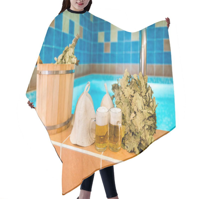 Personality  Bath Accessories In The Russian Bath. Bathroom Items Of Traditional Russian Sauna. Two Mugs Of Light Beer, Bathing Caps, Bath Brooms From Oak Leaves Against The Background Of The Pool. Hair Cutting Cape