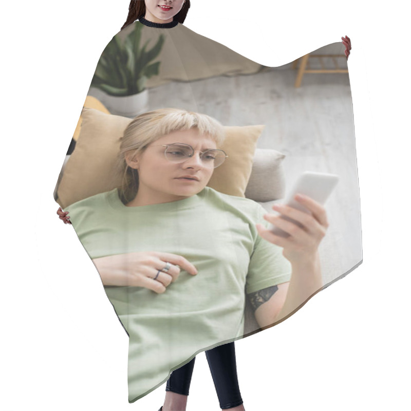 Personality  Overhead View Of Young Woman With Tattoo, Blonde And Short Hair, Bangs And Eyeglasses Using Smartphone While Resting On Comfortable Couch Near Guitar In Modern Living Room, Blurred Background Hair Cutting Cape