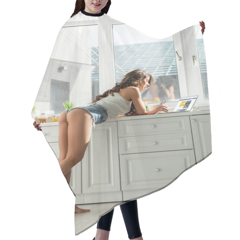 Personality  KYIV, UKRAINE - MARCH 13, 2020: Side View Of Attractive Girl Using Booking Website On Laptop In Kitchen  Hair Cutting Cape