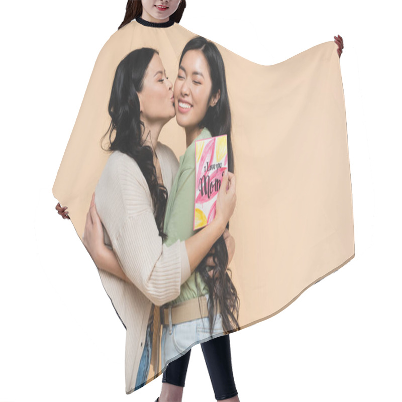 Personality  Brunette Asian Mother Holding Greeting Card And Kissing Happy Adult Daughter Isolated On Beige Hair Cutting Cape