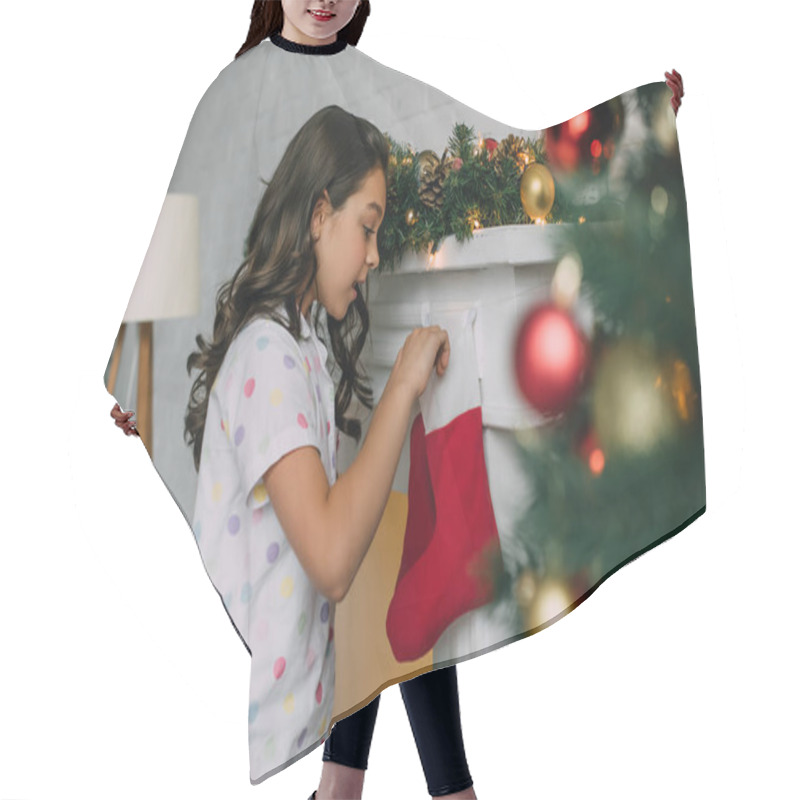 Personality  Side View Of Shocked Child In Pajama Looking At Christmas Stocking Near Fireplace At Home  Hair Cutting Cape