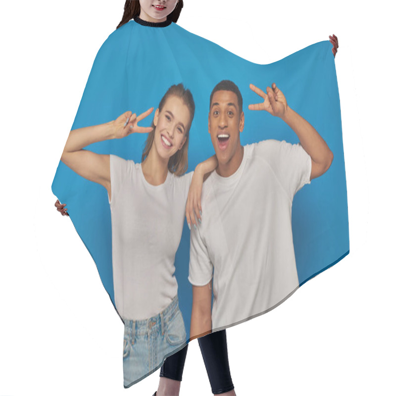 Personality  Happy Multicultural Couple Showing Peace Sign And Looking At Camera On Blue Background, Positivity Hair Cutting Cape