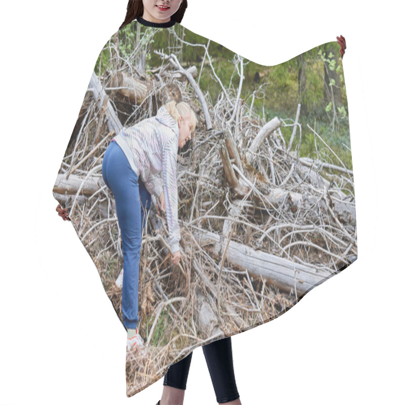 Personality  A Middle Aged Woman With Blond Hair Collects Dry Branches In The Forest. Collecting Brushwood Hair Cutting Cape