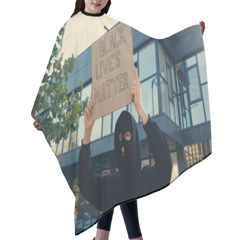 Personality  Activist In Balaclava Holding Placard With Black Lives Matter Lettering Near Modern Building Outside Hair Cutting Cape